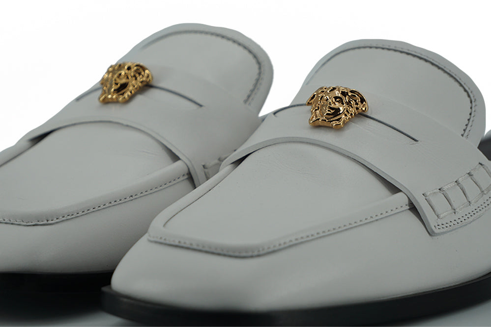 Elegantes chanclas planas de cuero blanco