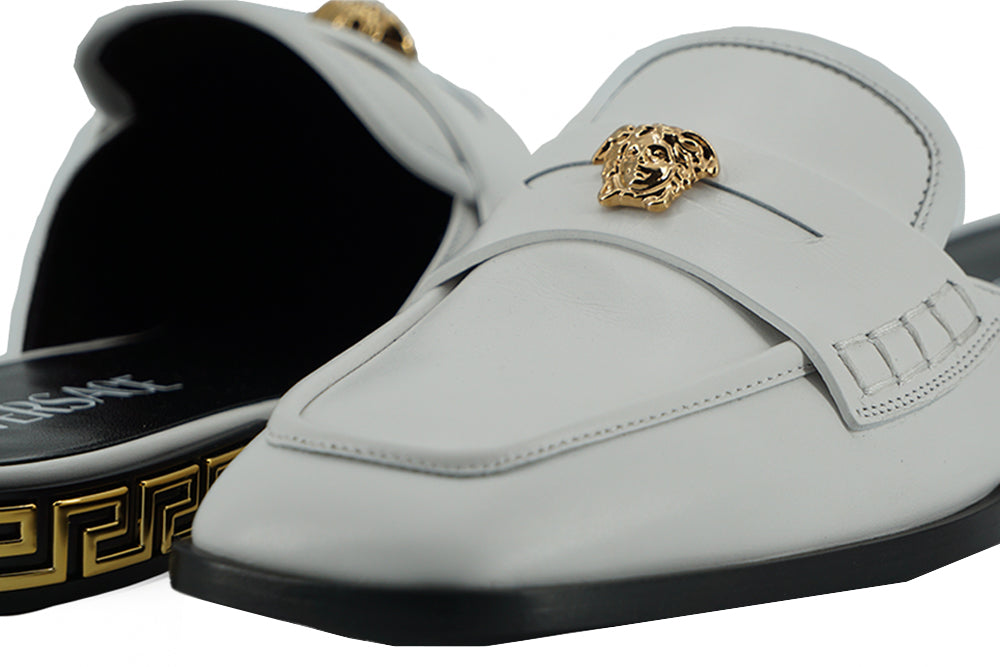 Elegantes chanclas planas de cuero blanco