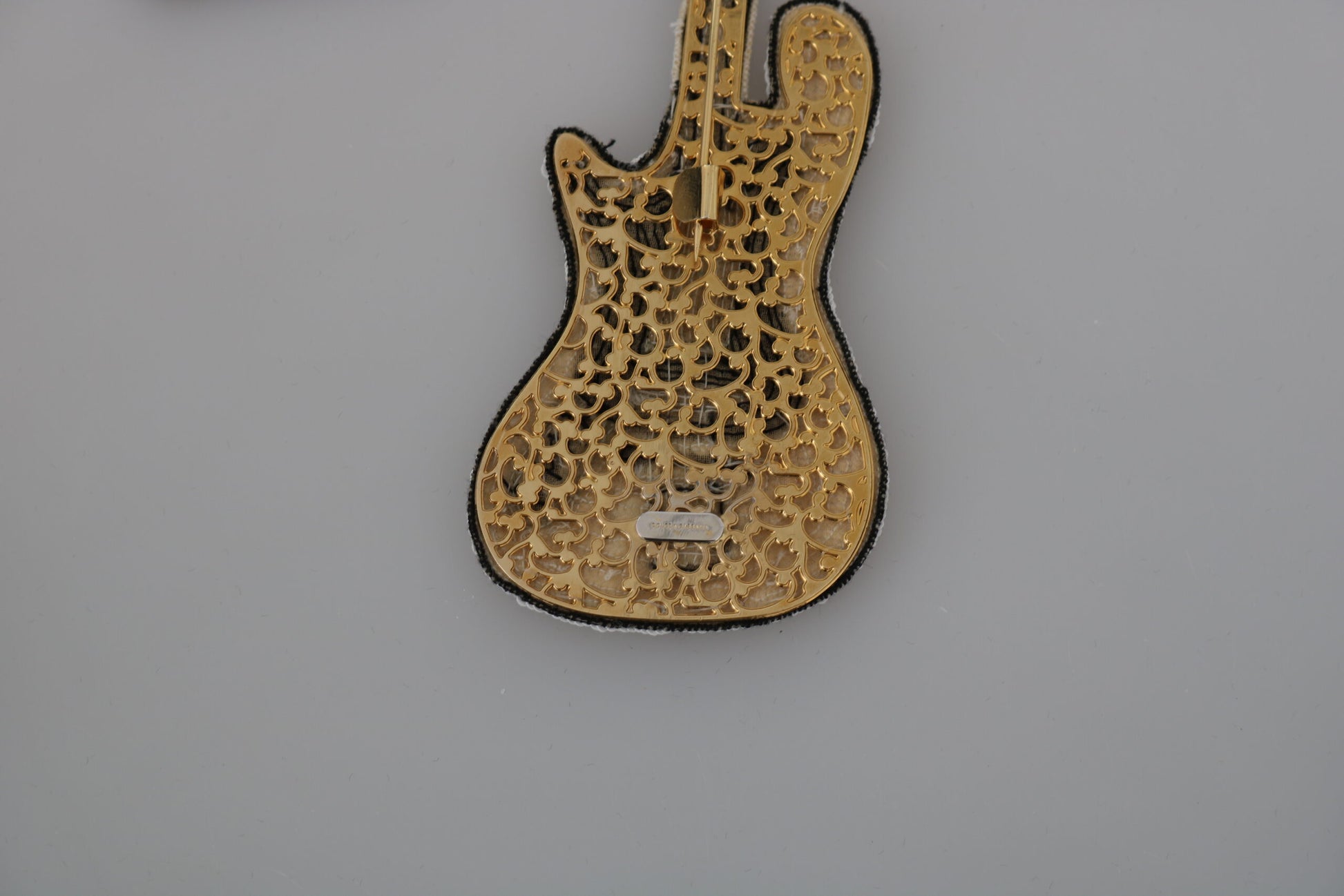 Broche de guitarra con lentejuelas doradas