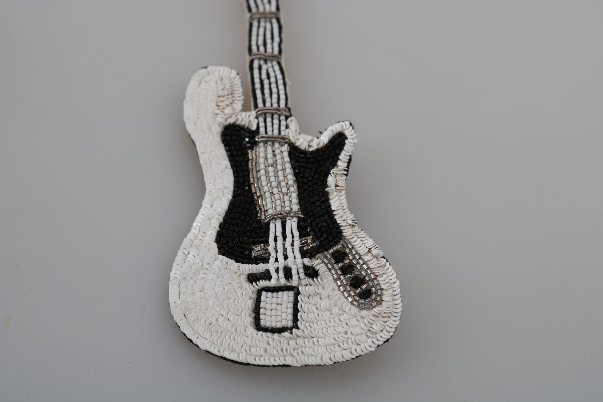 Broche de guitarra con lentejuelas doradas